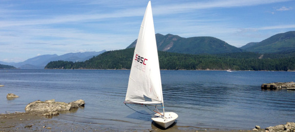 Snake Bay Sailing Club Laser with a reefed sail on the shores of Porpoise Bay in Sechelt, BC.