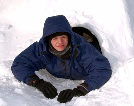Robert Dall coming out the igloo he spent a night in.